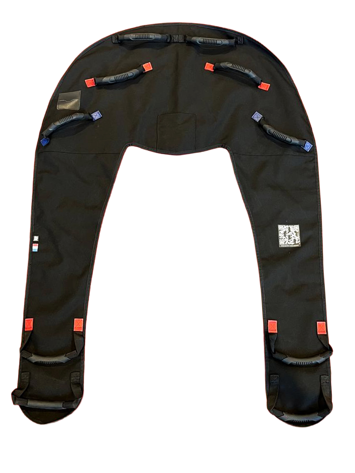 Black parachute/harness with leg loops and multiple red pull tabs, used to secure a skydiving or paragliding system
